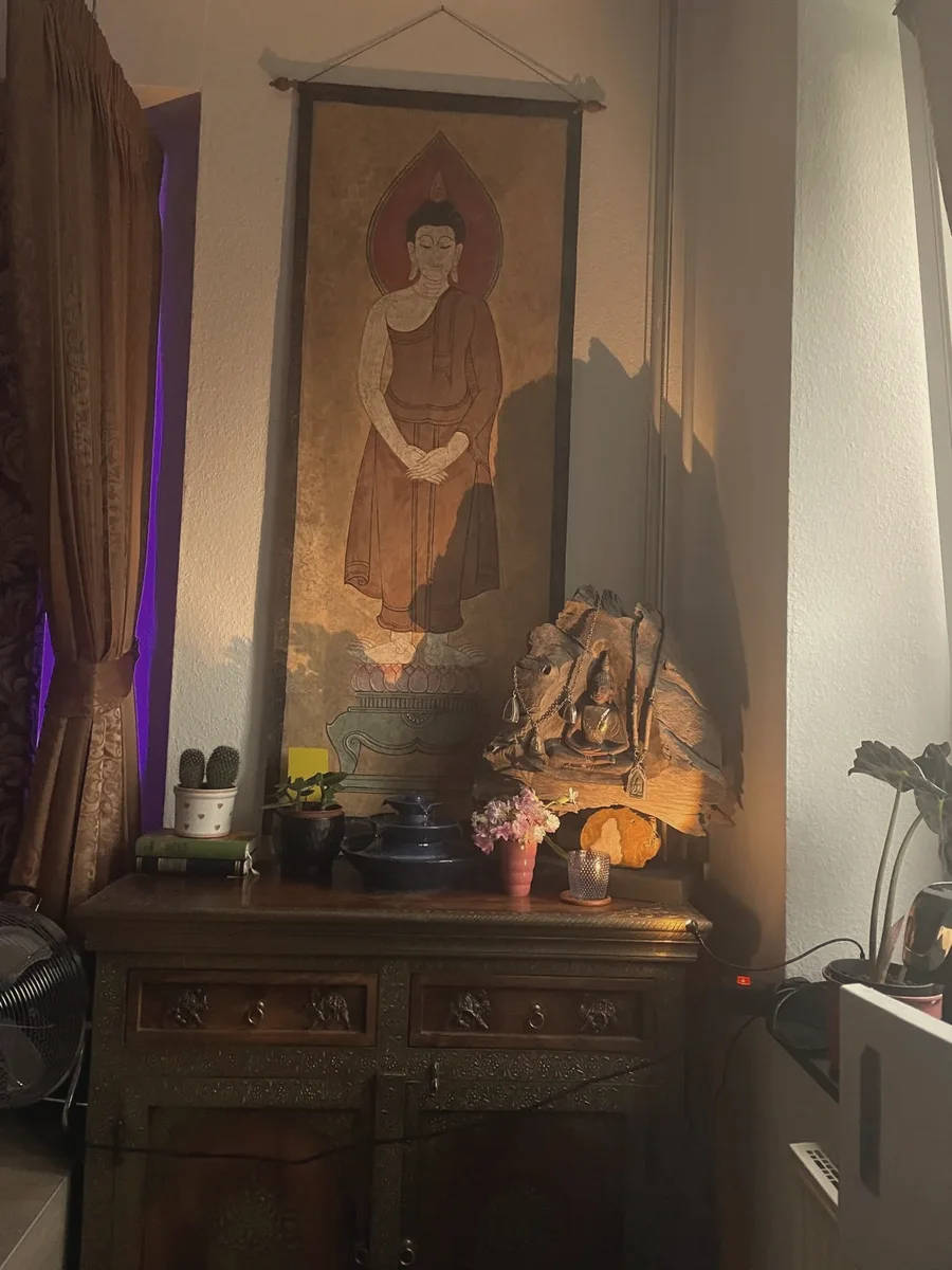 Thailändisches Wandbild über einer Holzkommode im Kerzenlicht